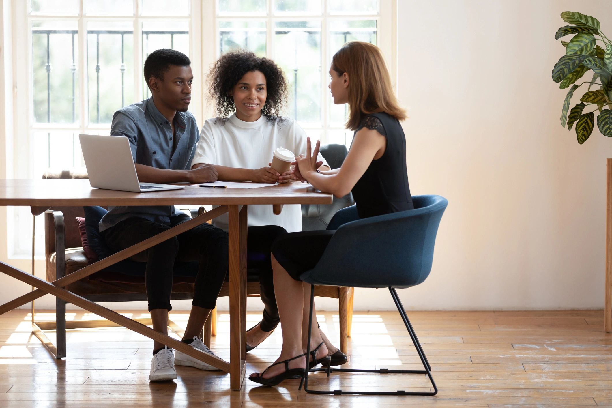 Couple meeting with real estate agent to discuss buying a home