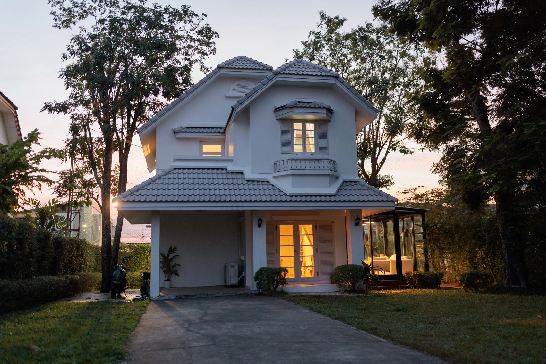 Residential home exterior at dusk with lights on